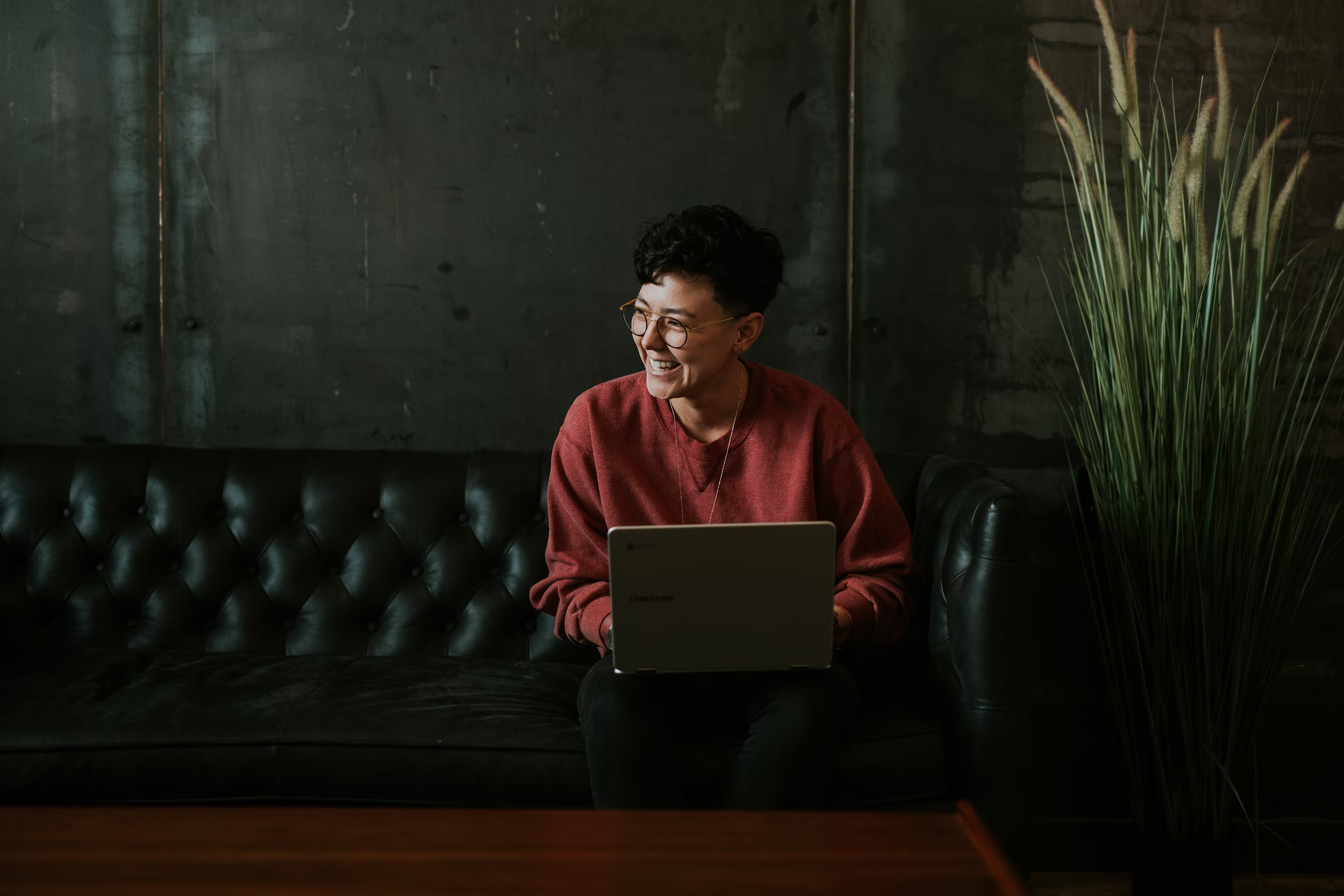 Person sitting on couch working on laptop